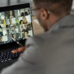 Man sitting at desk participating in an online meeting.